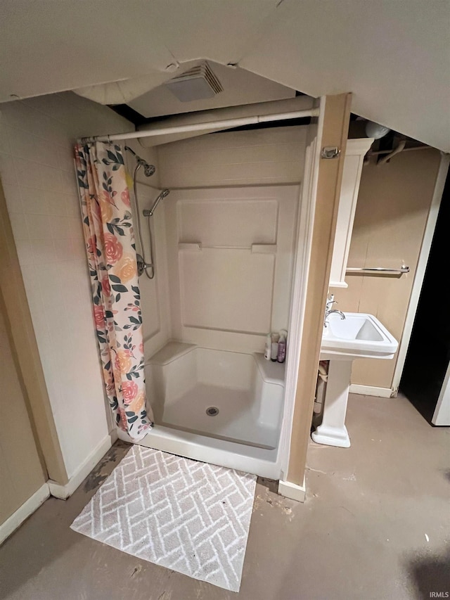 bathroom with concrete floors and curtained shower