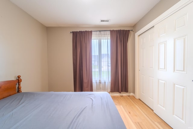 bedroom with light hardwood / wood-style floors and a closet