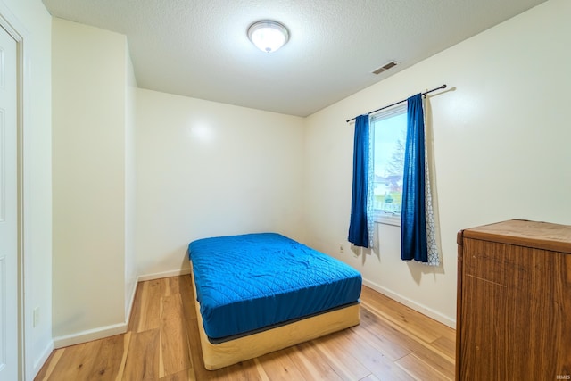 bedroom featuring a textured ceiling and hardwood / wood-style flooring