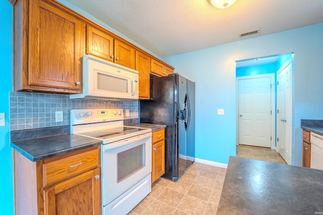 kitchen featuring decorative backsplash, a textured ceiling, and white appliances