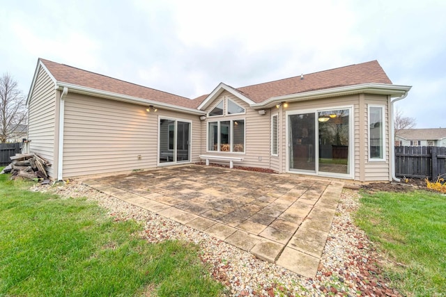 rear view of house featuring a lawn and a patio area