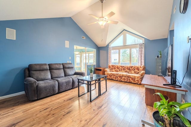 living room featuring ceiling fan, plenty of natural light, light hardwood / wood-style floors, and vaulted ceiling