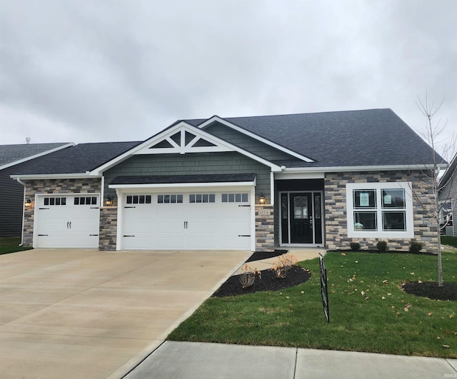 craftsman house featuring a garage and a front lawn