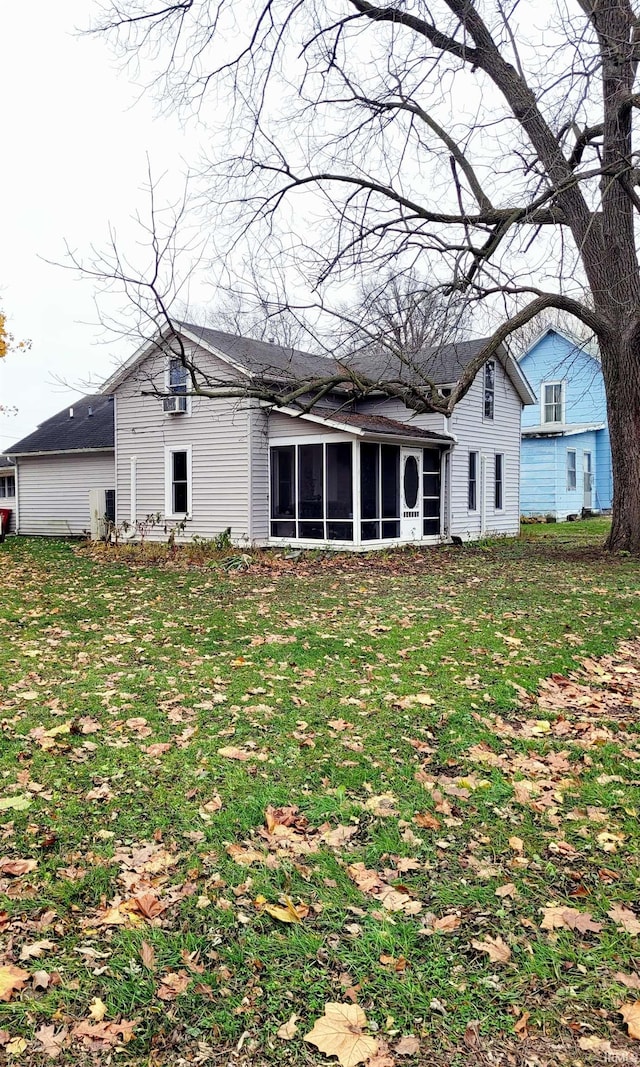 rear view of house featuring a sunroom and a yard