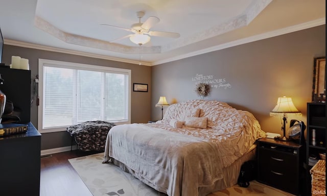 bedroom featuring dark hardwood / wood-style floors, a raised ceiling, ceiling fan, and crown molding