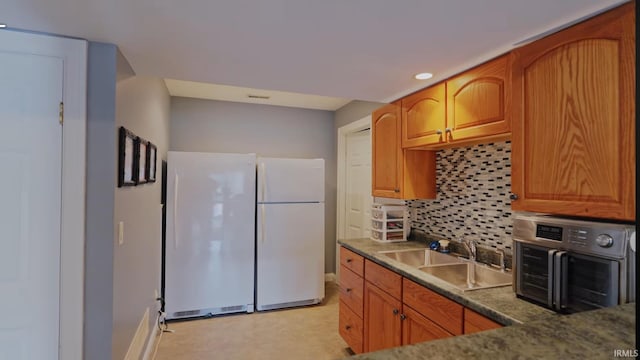 kitchen featuring white fridge, tasteful backsplash, and sink