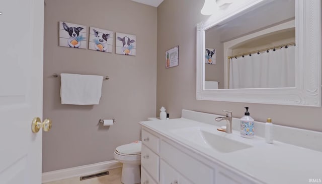 bathroom featuring tile patterned flooring, vanity, and toilet