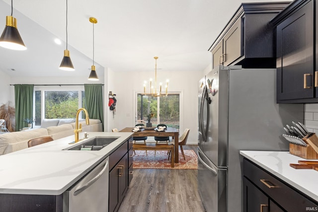 kitchen with dishwasher, sink, dark wood-type flooring, an inviting chandelier, and pendant lighting