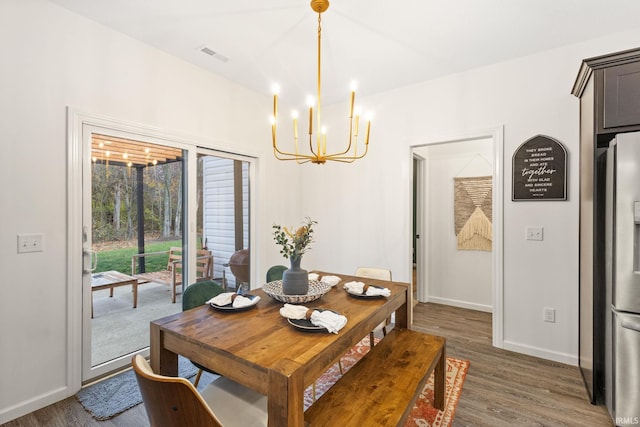 dining space featuring a notable chandelier and dark wood-type flooring