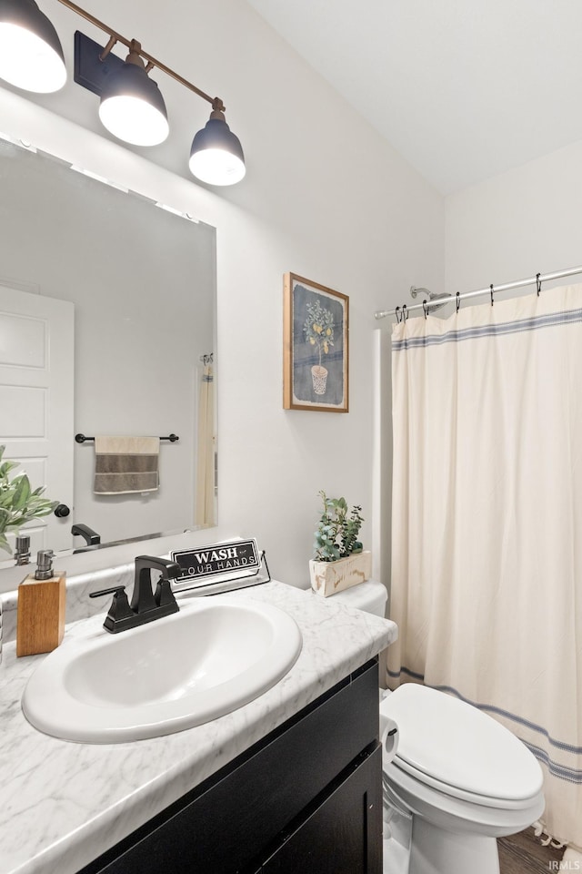 bathroom with a shower with shower curtain, vanity, and toilet