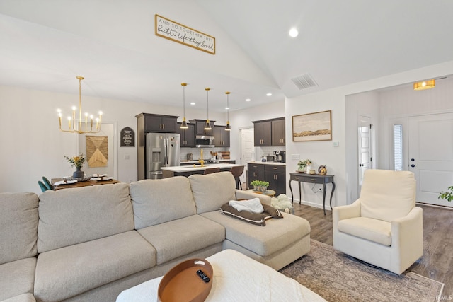 living room with dark hardwood / wood-style flooring, high vaulted ceiling, and a notable chandelier