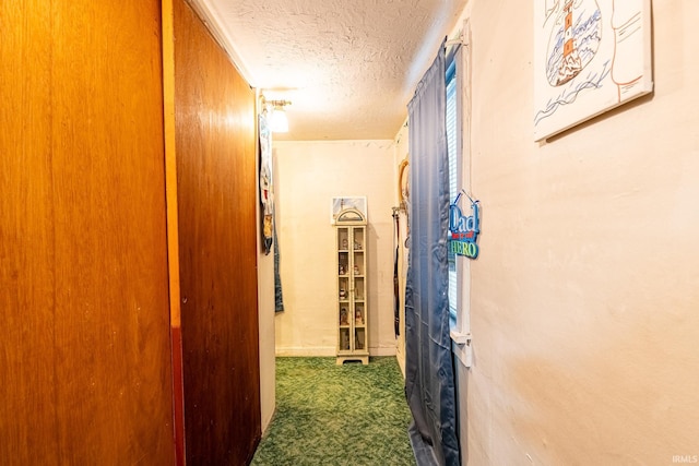 corridor featuring carpet flooring and a textured ceiling