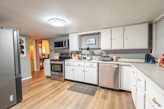 kitchen with white cabinetry, light hardwood / wood-style flooring, stainless steel appliances, and sink