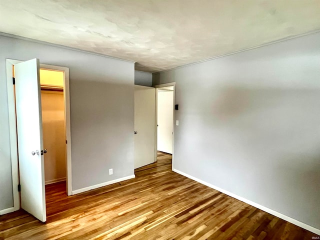 unfurnished bedroom with a walk in closet, light wood-type flooring, and a closet