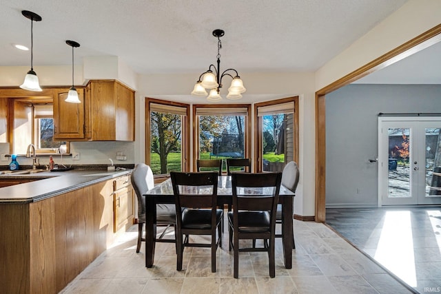 dining space with a chandelier, a textured ceiling, and sink