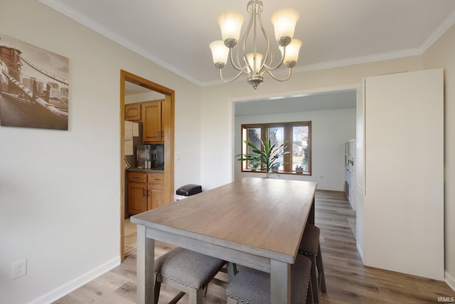 dining space with a chandelier, light hardwood / wood-style flooring, and crown molding