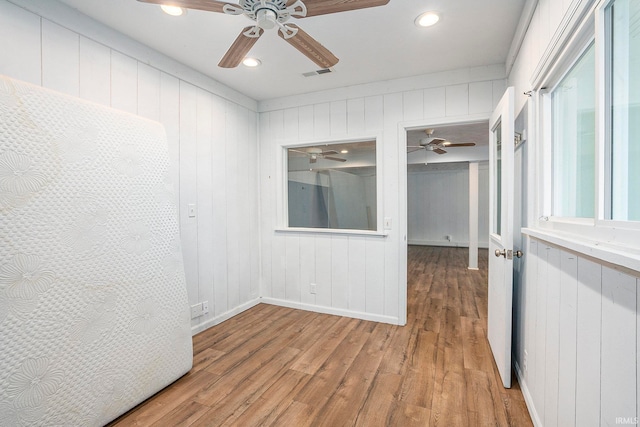 spare room featuring light wood-type flooring and wood walls