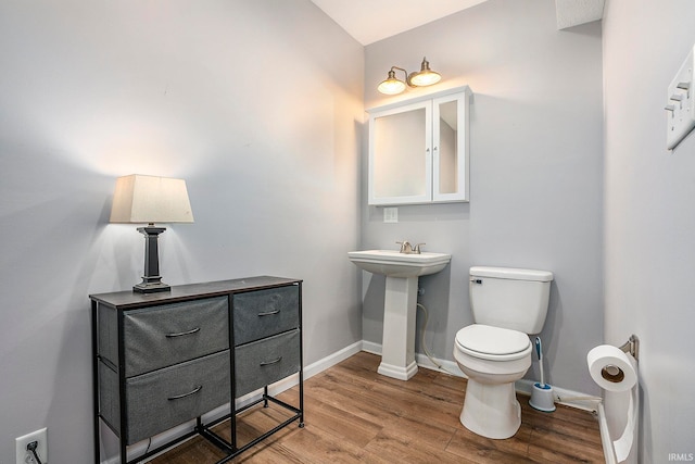 bathroom with hardwood / wood-style flooring, toilet, and sink