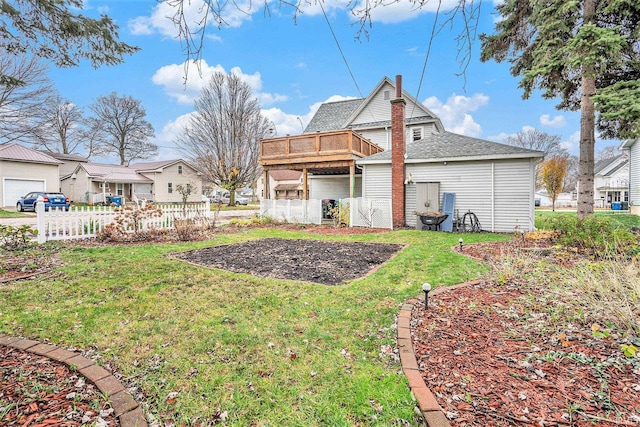 rear view of property featuring a yard and a wooden deck