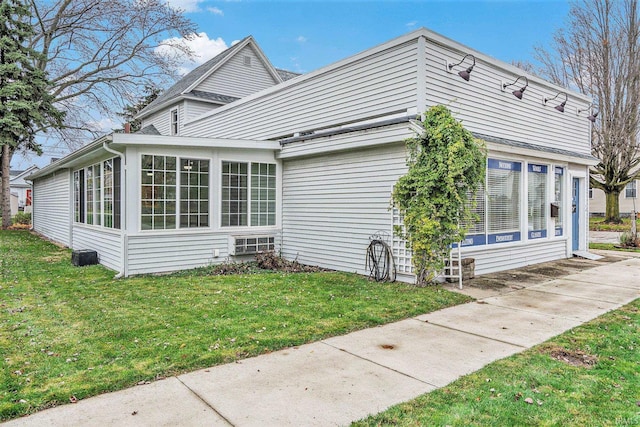 view of home's exterior with a yard and a sunroom