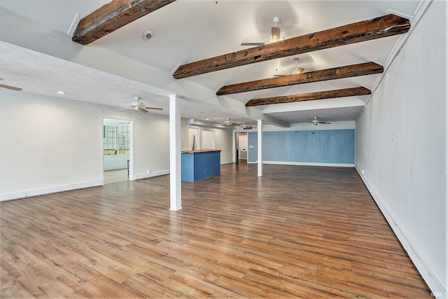 unfurnished living room featuring beamed ceiling and hardwood / wood-style flooring