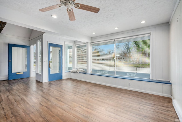 unfurnished room with ceiling fan, light hardwood / wood-style floors, a textured ceiling, and a wealth of natural light