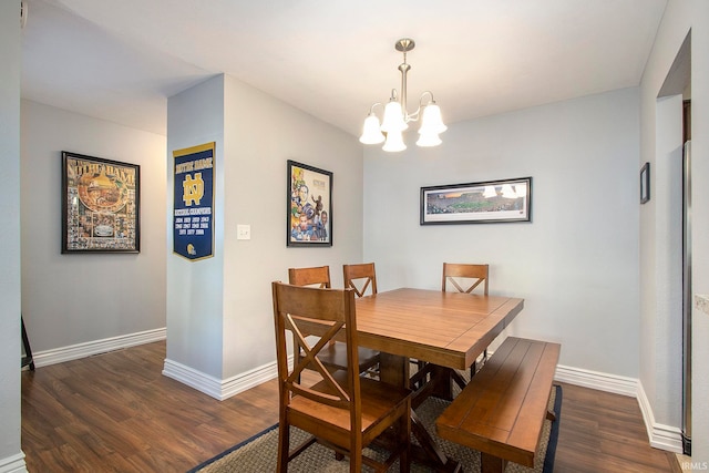 dining space with dark hardwood / wood-style flooring and a chandelier