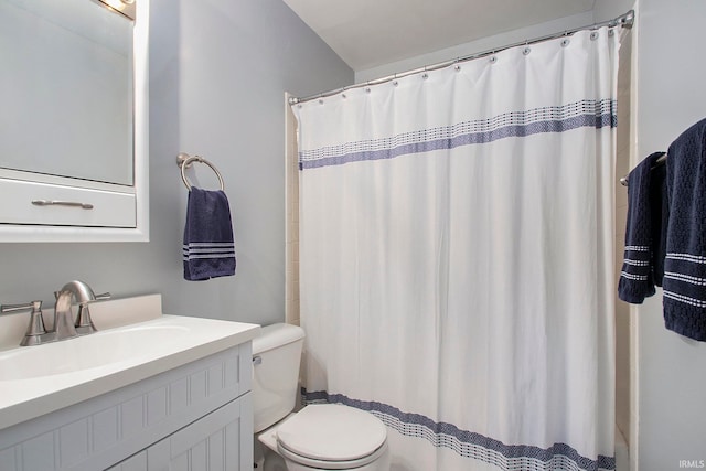 bathroom featuring curtained shower, vanity, and toilet