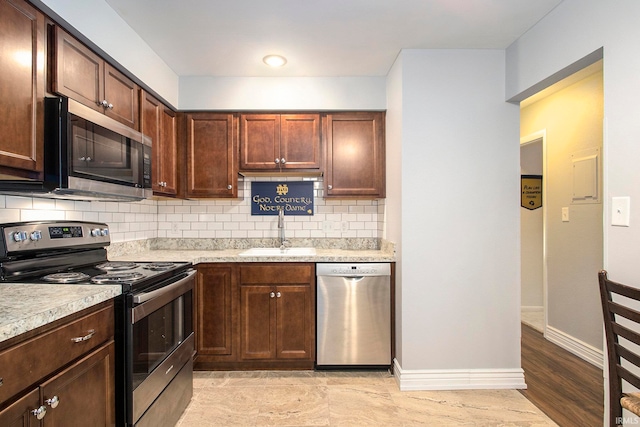 kitchen with decorative backsplash, dark brown cabinetry, stainless steel appliances, sink, and light hardwood / wood-style floors