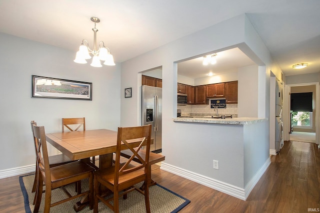 dining space featuring dark wood-type flooring and a chandelier