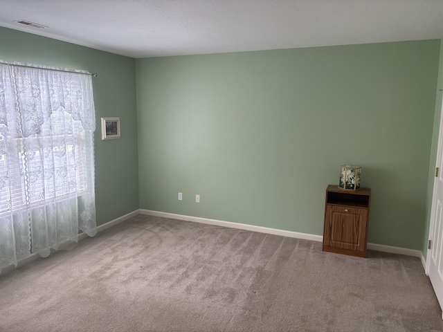 unfurnished room featuring light carpet