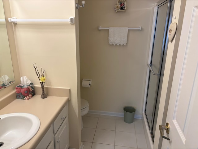 bathroom featuring tile patterned flooring, vanity, toilet, and walk in shower