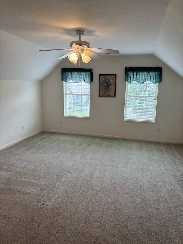 additional living space featuring plenty of natural light, ceiling fan, light colored carpet, and lofted ceiling