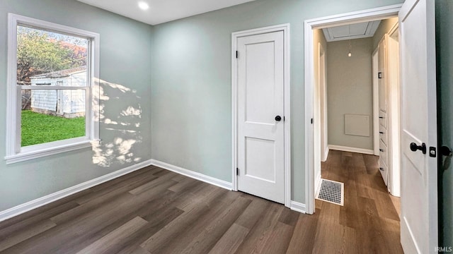 spare room with dark hardwood / wood-style flooring and a healthy amount of sunlight