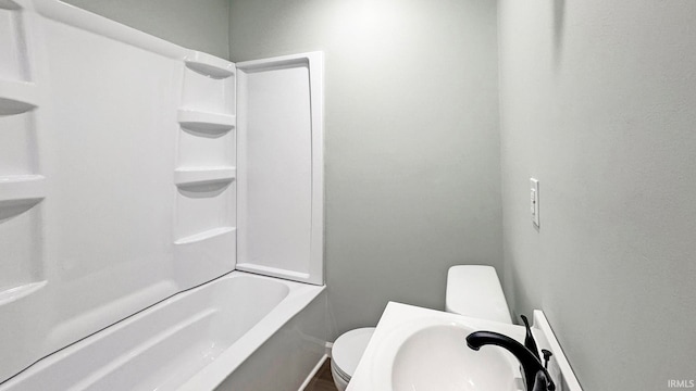 bathroom featuring washtub / shower combination and toilet