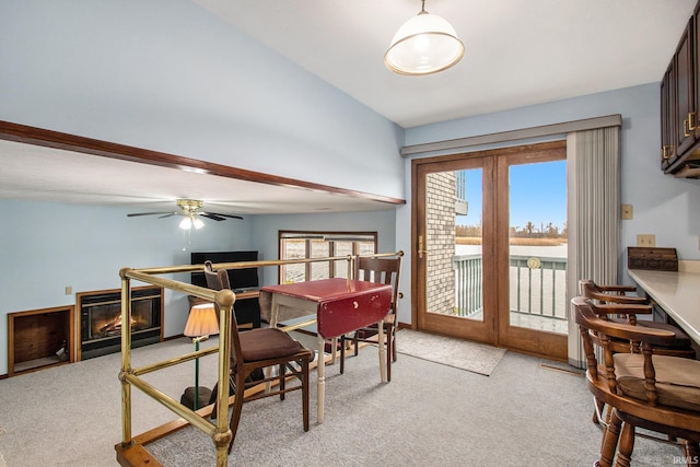 carpeted dining area with ceiling fan, french doors, and lofted ceiling