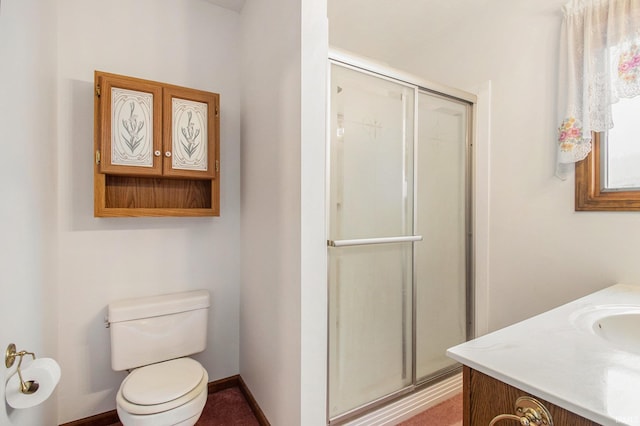 bathroom featuring vanity, toilet, and walk in shower