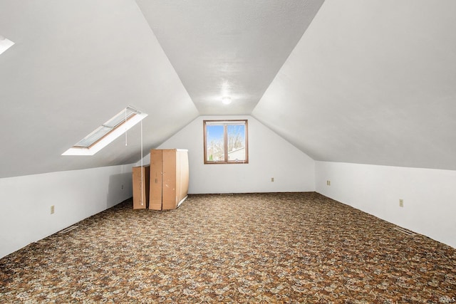 additional living space featuring carpet flooring and lofted ceiling with skylight