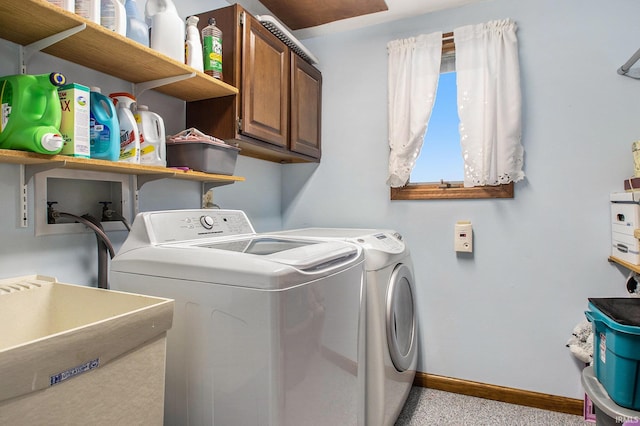 clothes washing area featuring washing machine and dryer, sink, and cabinets