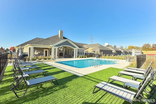 view of swimming pool with a yard and a patio