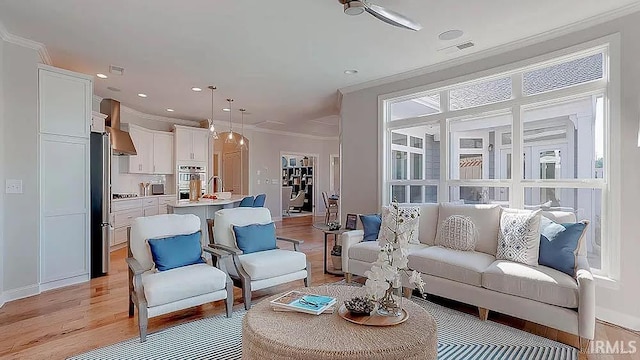 living room featuring light hardwood / wood-style flooring and crown molding