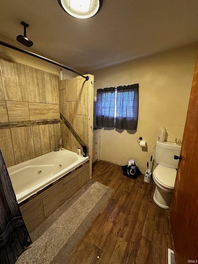 bathroom featuring hardwood / wood-style floors, shower / bathing tub combination, a textured ceiling, and toilet