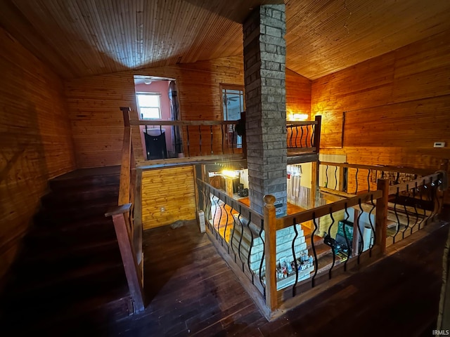 hallway with wood walls, dark hardwood / wood-style flooring, wood ceiling, and vaulted ceiling