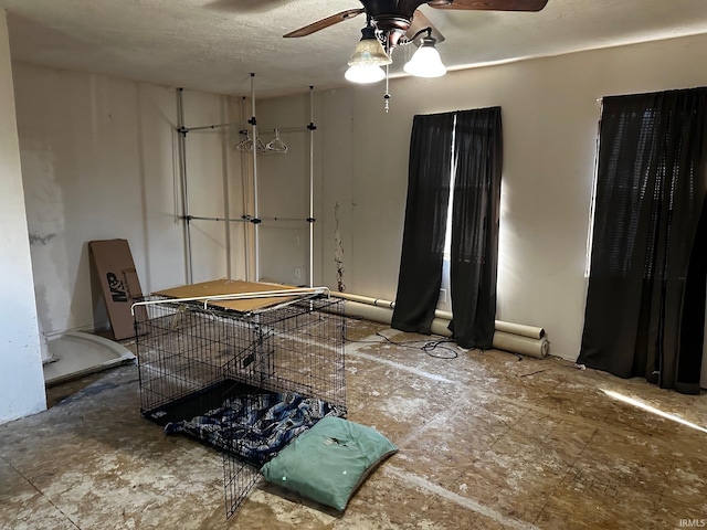 miscellaneous room with a textured ceiling and ceiling fan