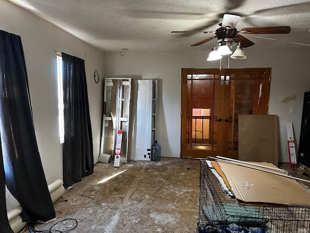 interior space with ceiling fan and a textured ceiling