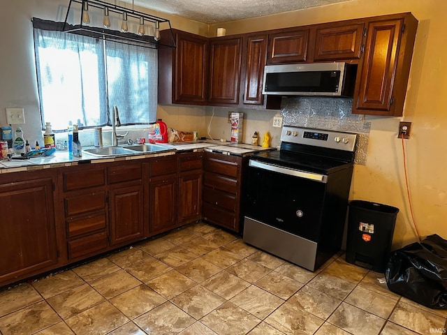 kitchen featuring tasteful backsplash, sink, a textured ceiling, and appliances with stainless steel finishes