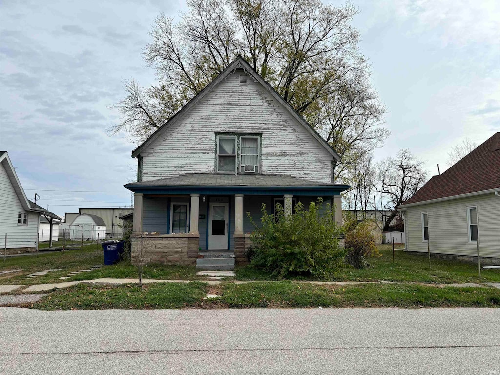 bungalow with a front lawn and covered porch