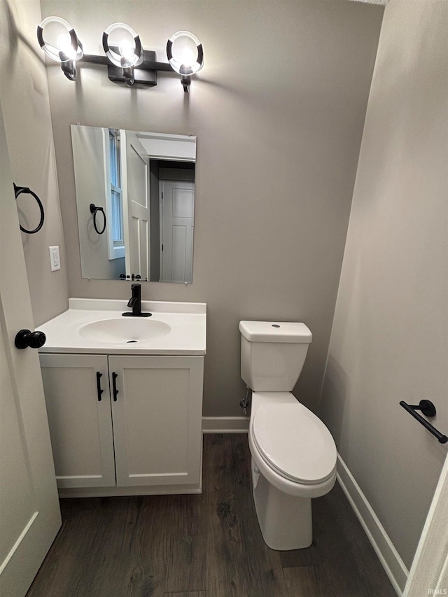 bathroom with hardwood / wood-style floors, vanity, and toilet