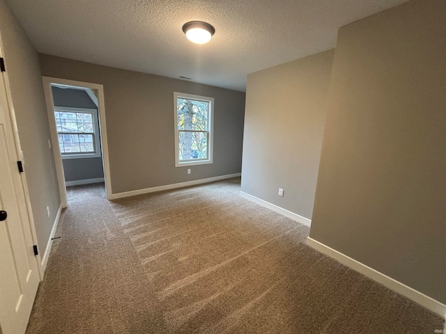 carpeted spare room featuring a textured ceiling