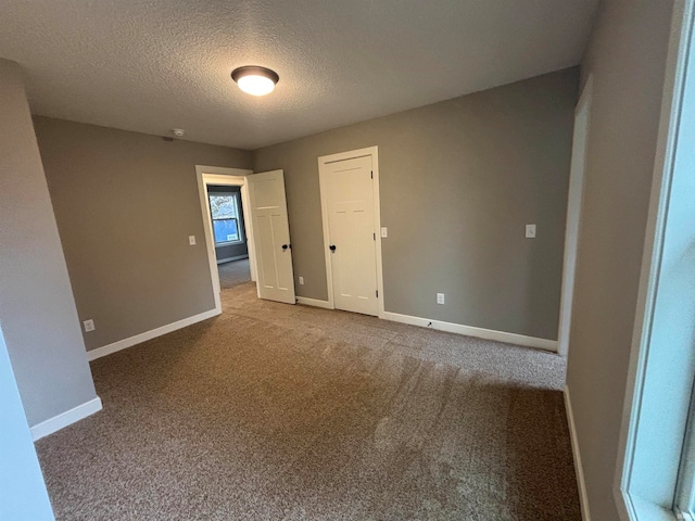 unfurnished bedroom featuring carpet and a textured ceiling